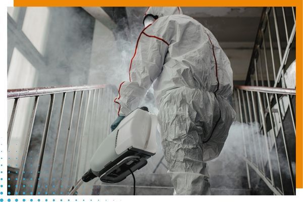 spraying stairway wearing PPE