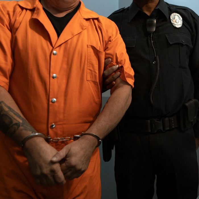 person in orange jumpsuit with correction officer 
