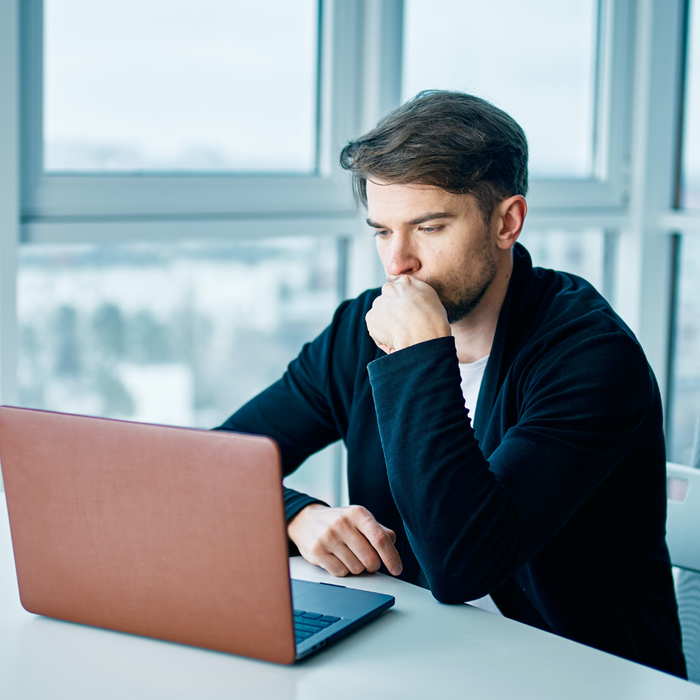 a man looking at a laptop, worried How to Conduct a Miami Dade Inmate Search4.png