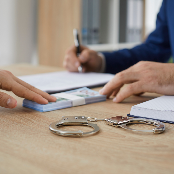 a man giving a bail bonds man money How to Conduct a Miami Dade Inmate Search1.png