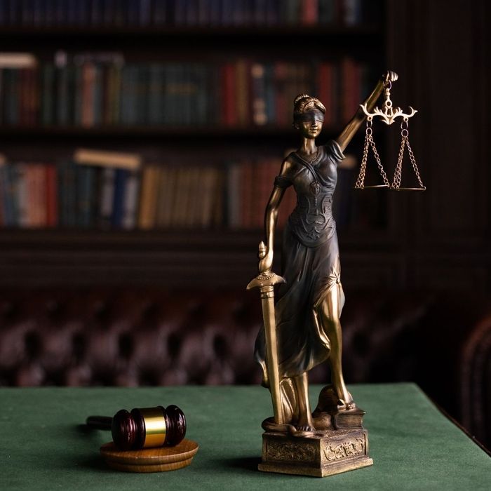 lady of justice next to a gavel in a room with law books lady of justice next to a gavel in a room with law books