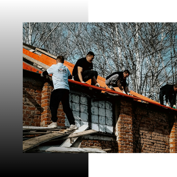 roofers working on the roof of a brick home