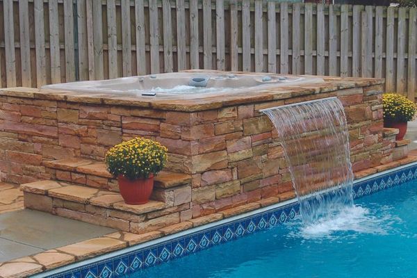 hot tub with a waterfall into a pool