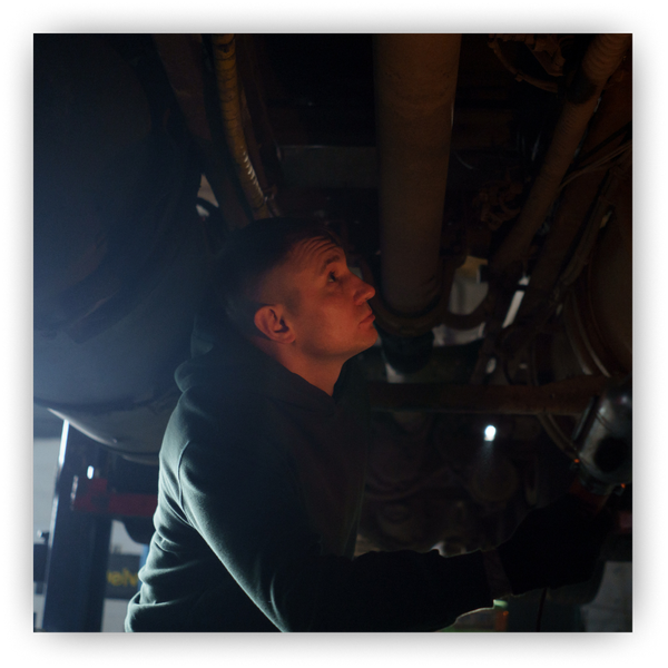 Man underneath a lifted car