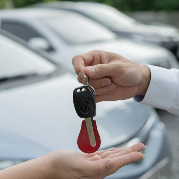 A car key being handed over to someone 