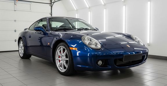 A professionally detailed blue sports car with a high-gloss finish in a clean garage.