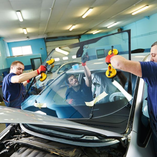two men replacing a windshield Get to Know the Founder.jpg