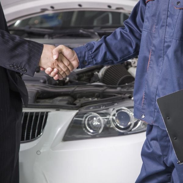 a mechanic shaking hands with a luxury vehicle owner Get to Know the Founder (3).jpg