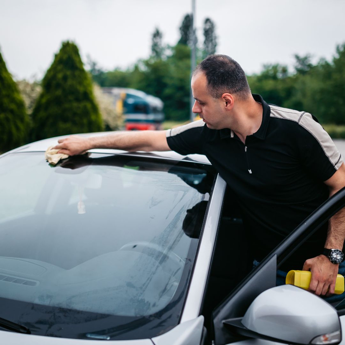 man wiping car windshield man wiping car windshield