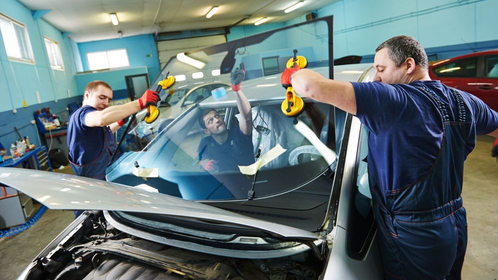 auto glass technicians replacing windshield
