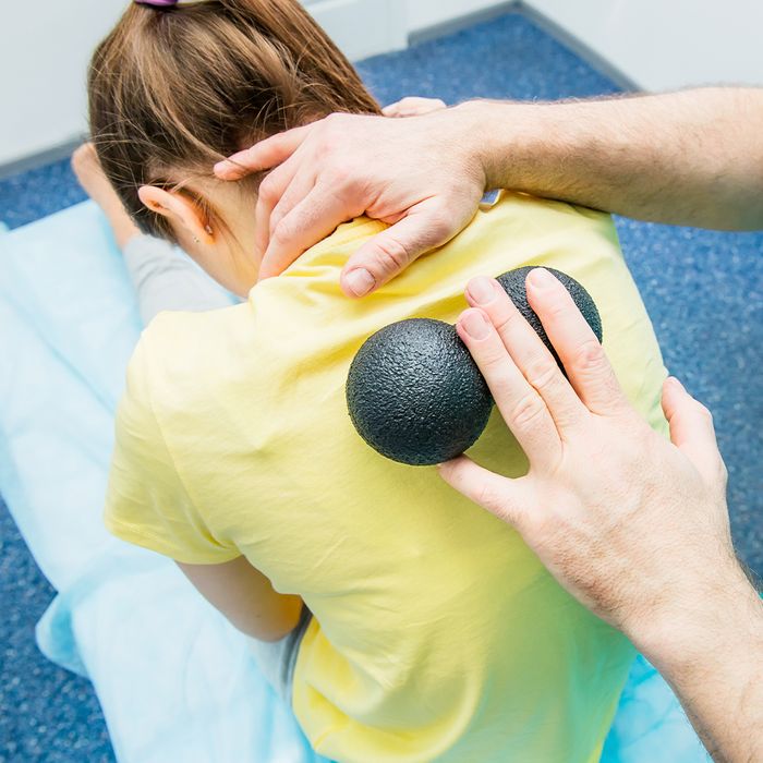 a girl getting a treatment with 2 foam balls