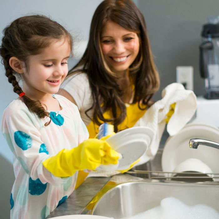 Mom doing dishes with child 