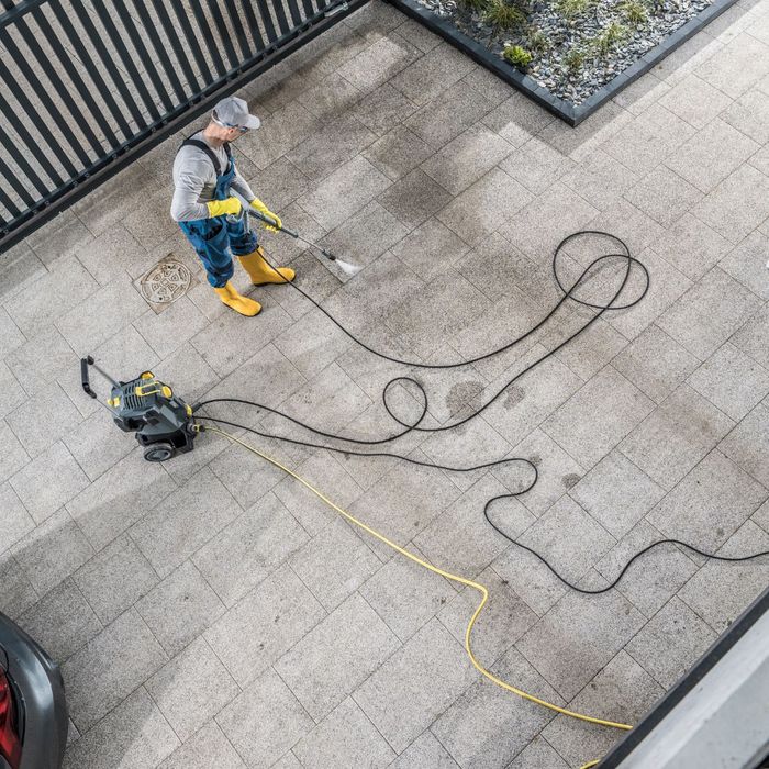 a person pressure washing a driveway