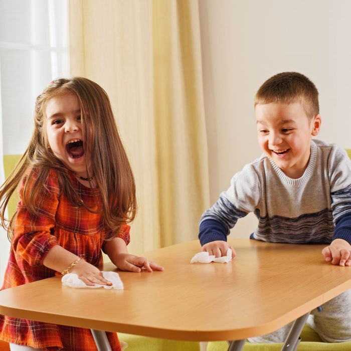 Kids laughing while cleaning a table 