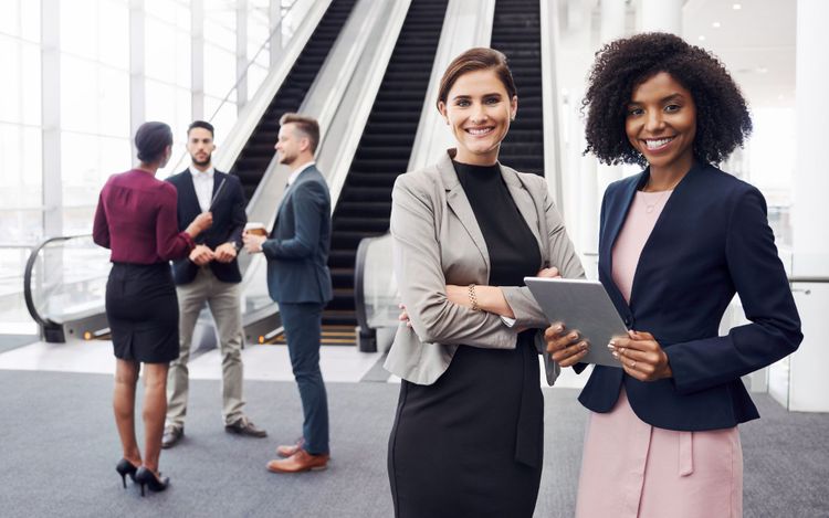 Professionally dressed people standing near an escalator