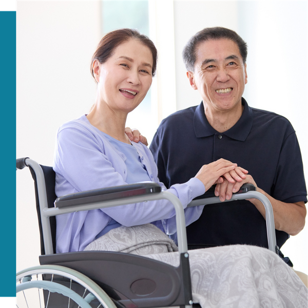 smiling older couple with woman in wheelchair