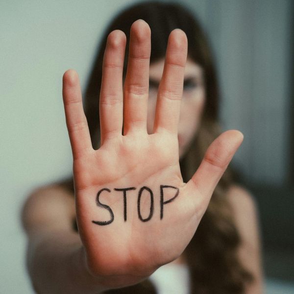 a woman with stop written on her hand Breaking the Cycle (3).jpg
