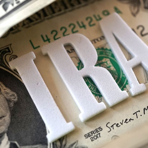 the letters 'IRA' on top of a dollar bill