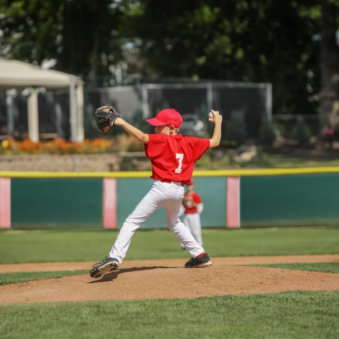 Young boy pitching a baseball. 