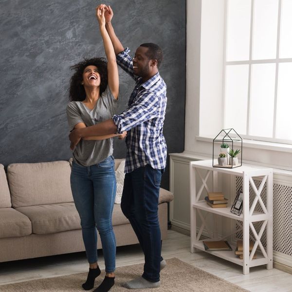 young couple dance in their living room