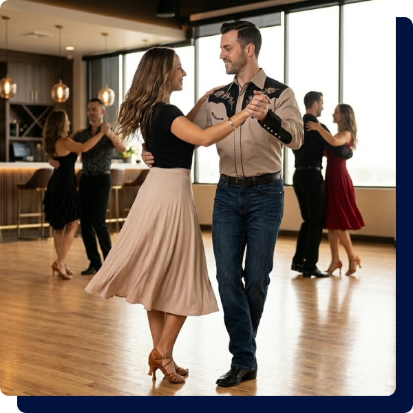 A couple smiling and gracefully executing a smooth synchronized Texas Two-Step turn on the polished wood floor during a Country Western class at Arthur Murray San Antonio.
