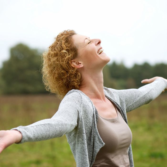 happy woman outside with outstretched arms