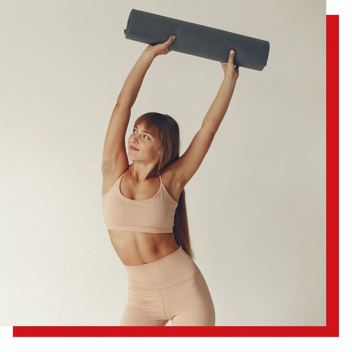 young woman holding yoga mat