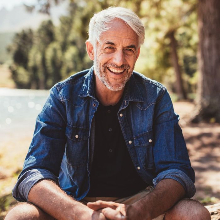 happy middle-aged man sitting in nature