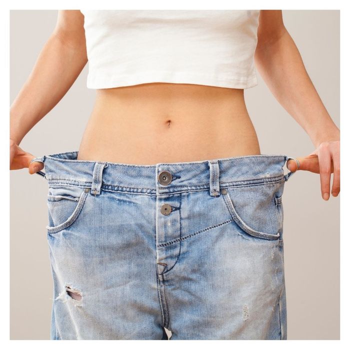 woman in oversized jeans after weight loss