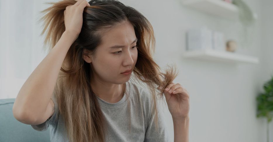 woman looking at split ends 