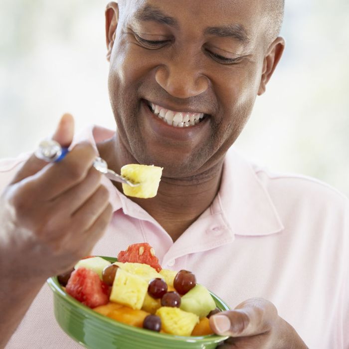 man eating bowl of fruit