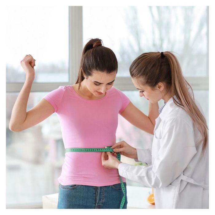 woman getting waist measured at weight loss clinic