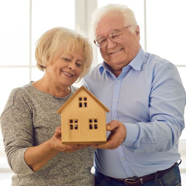 A retired couple holding a model of a house The Value of Personalized Financial Planning With TriState Wealth Advisors 1.jpg