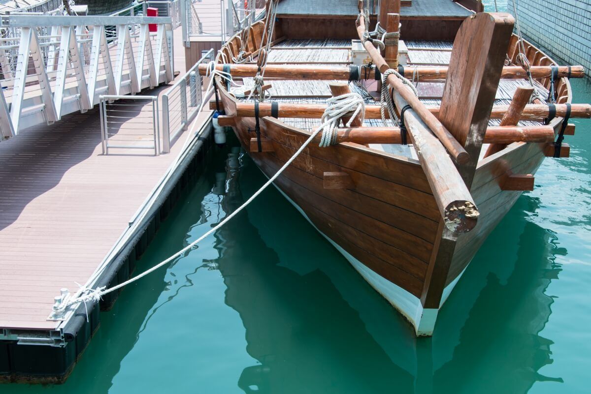 A wooden sailboat docked in the harbor.