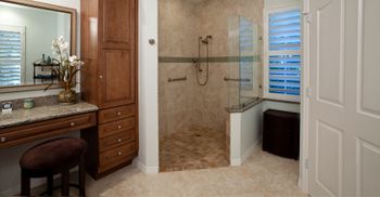 a corner shower with brown cabinets