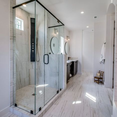 a glass shower in a white bathroom