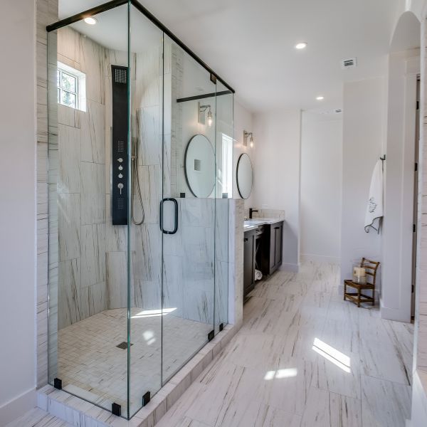 a glass shower in a white bathroom