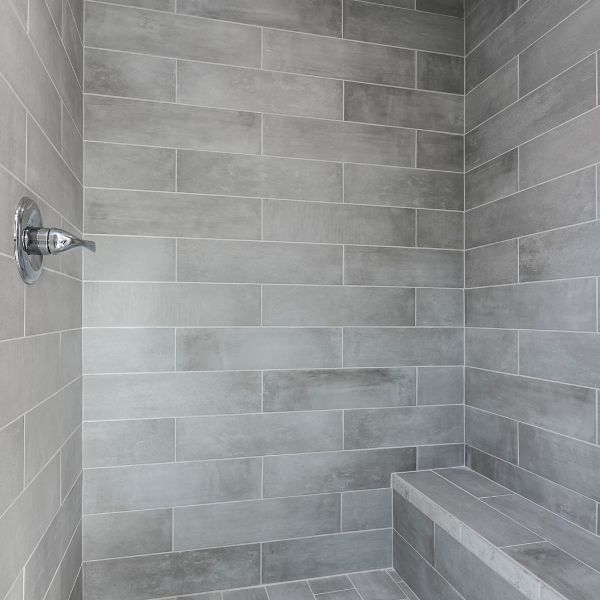 a stone tiled shower with a bench