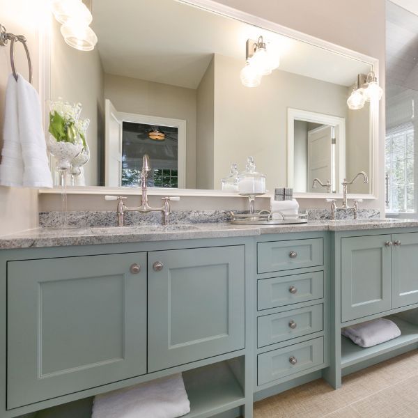 a bathroom with blue green cabinets