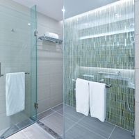 a glass shower with a colorful tile wall