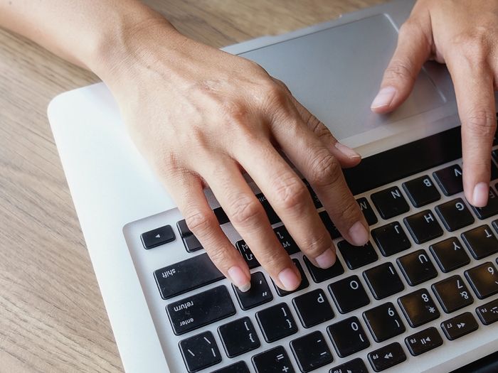 An image of a person’s hands on a keyboard.