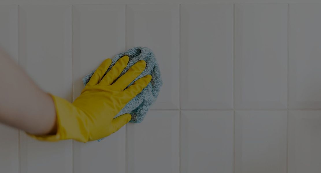person cleaning a wall backsplash. 