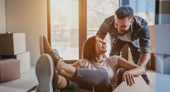 woman in a moving box smiling back at a man. 