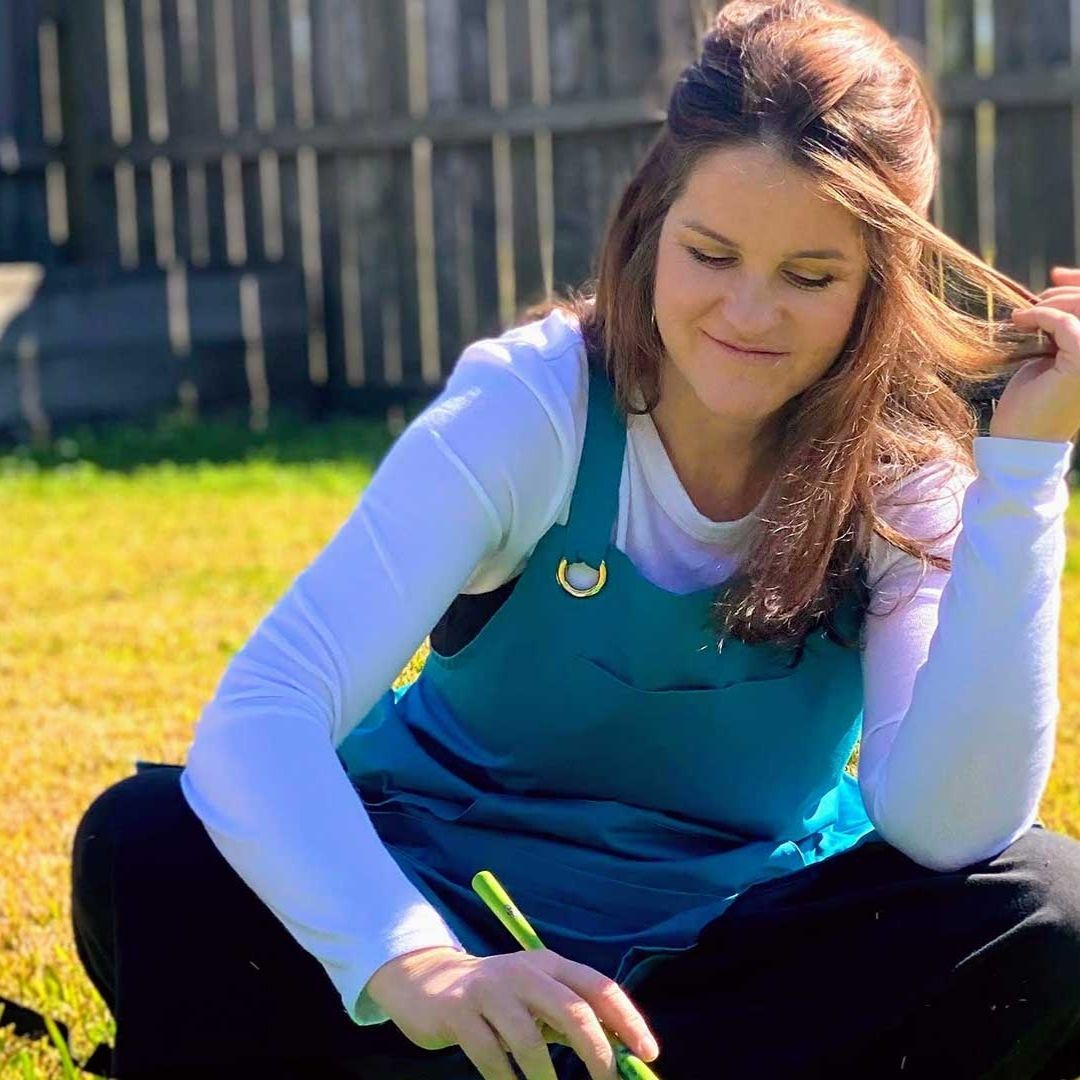 Rachael painting while sitting on grass