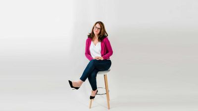 Rachael smiling while sitting on stool