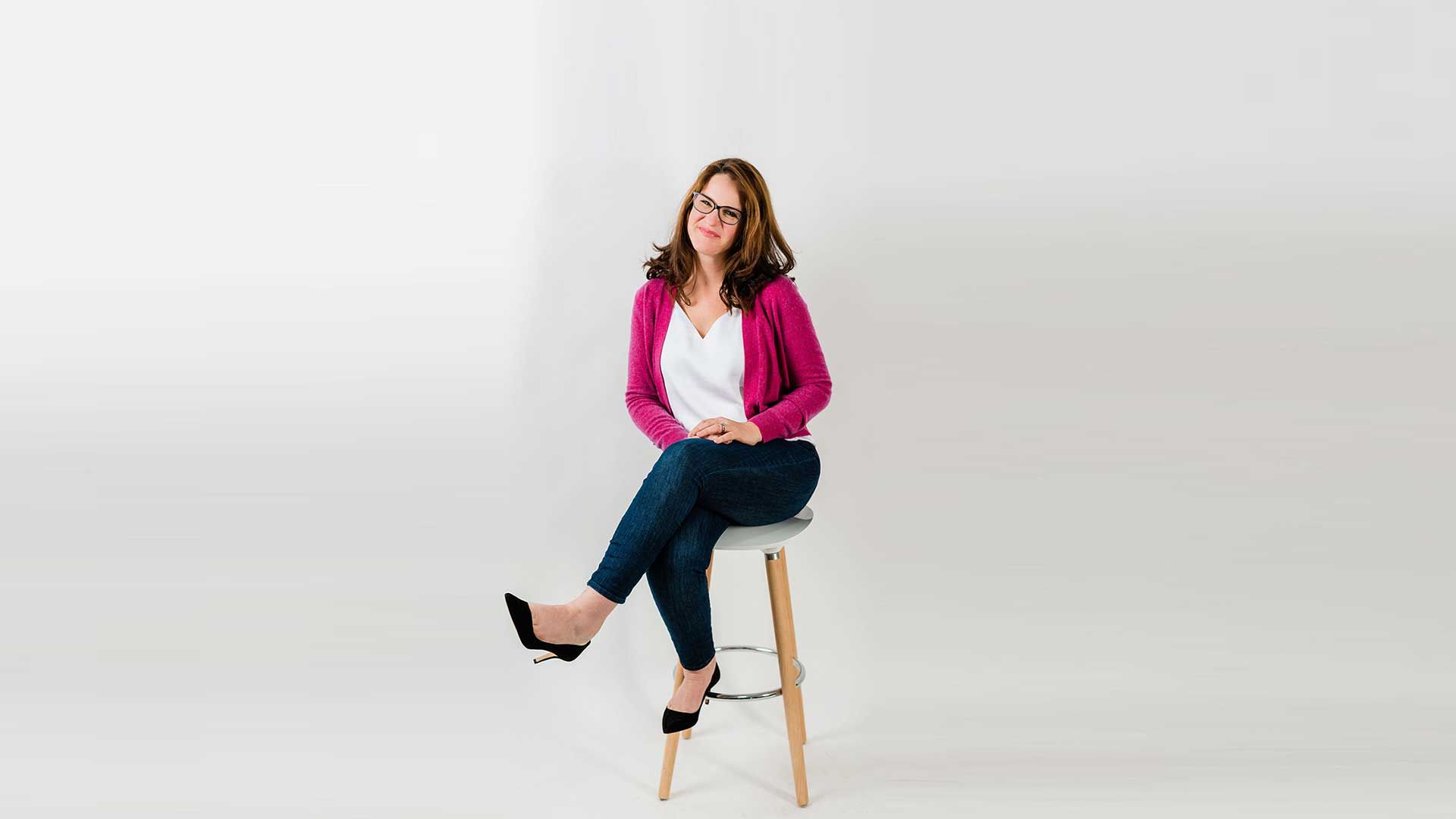 Rachael smiling while sitting on stool