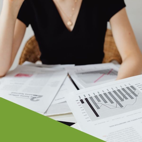 woman sitting at desk reviewing financial paperwork