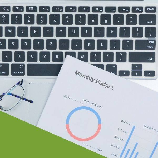 a monthly budget lying on top of keyboard