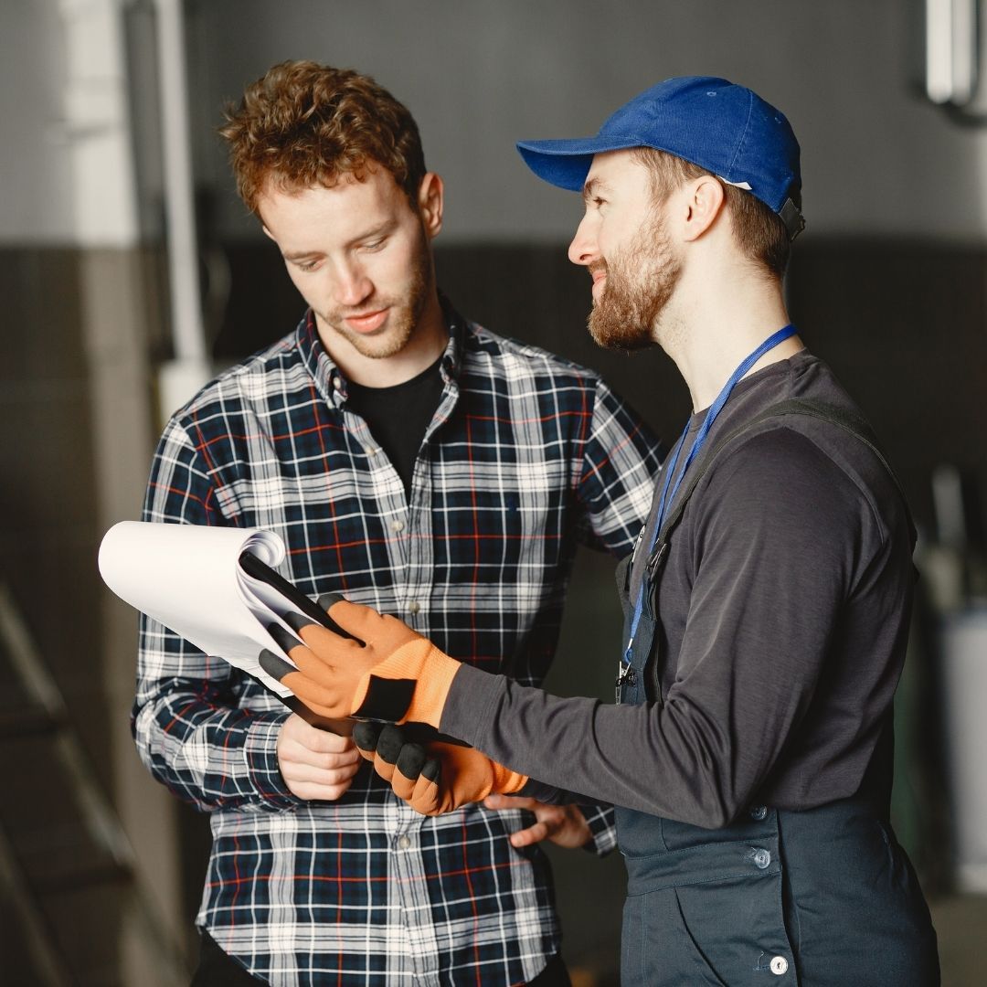 mechanic speaking with driver while showing clipboard mechanic speaking with driver while showing clipboard