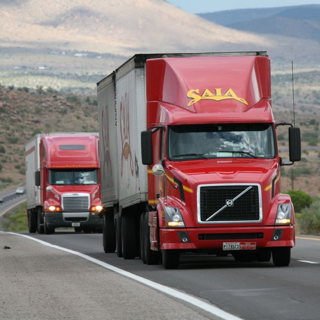 two red semi trucks driving on highway two red semi trucks driving on highway